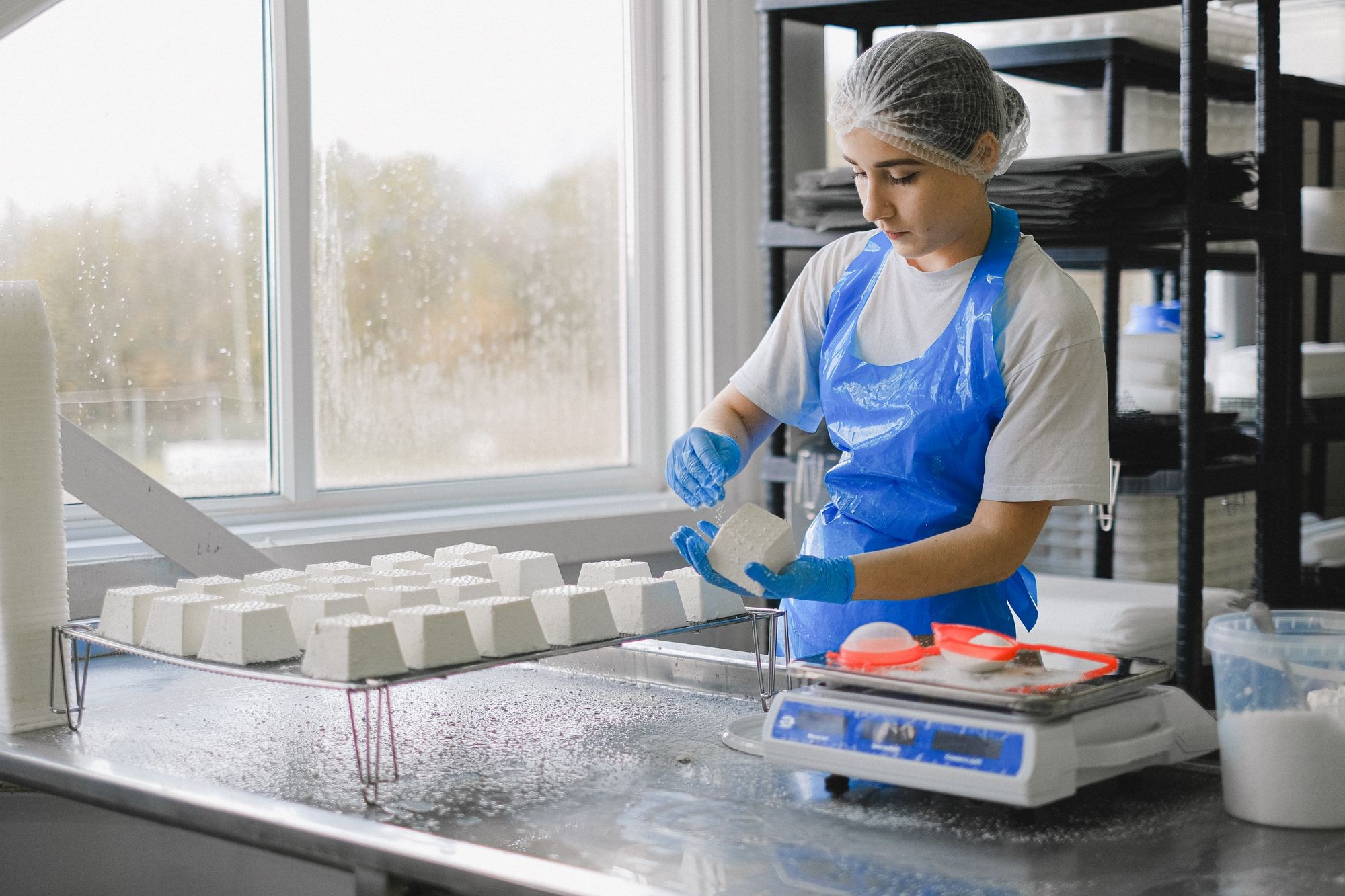 Production worker handling food products at a work table